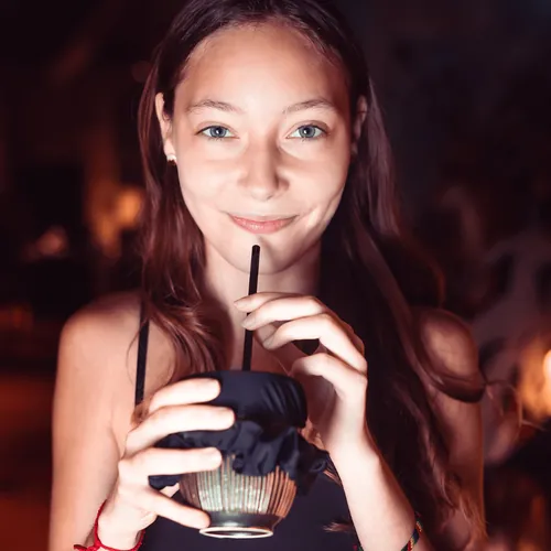Chica bebiendo con pajita de un vaso tapado con un coletero Tailsip